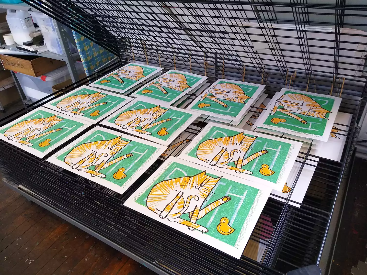 orange and white tabby cat screen prints on drying rack