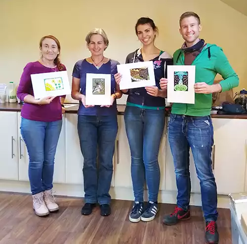 students on lino printing workshop with finished linocut prints